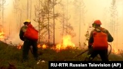 Firefighters work on a site of a forest fire in Yakutia in Russia Far East.