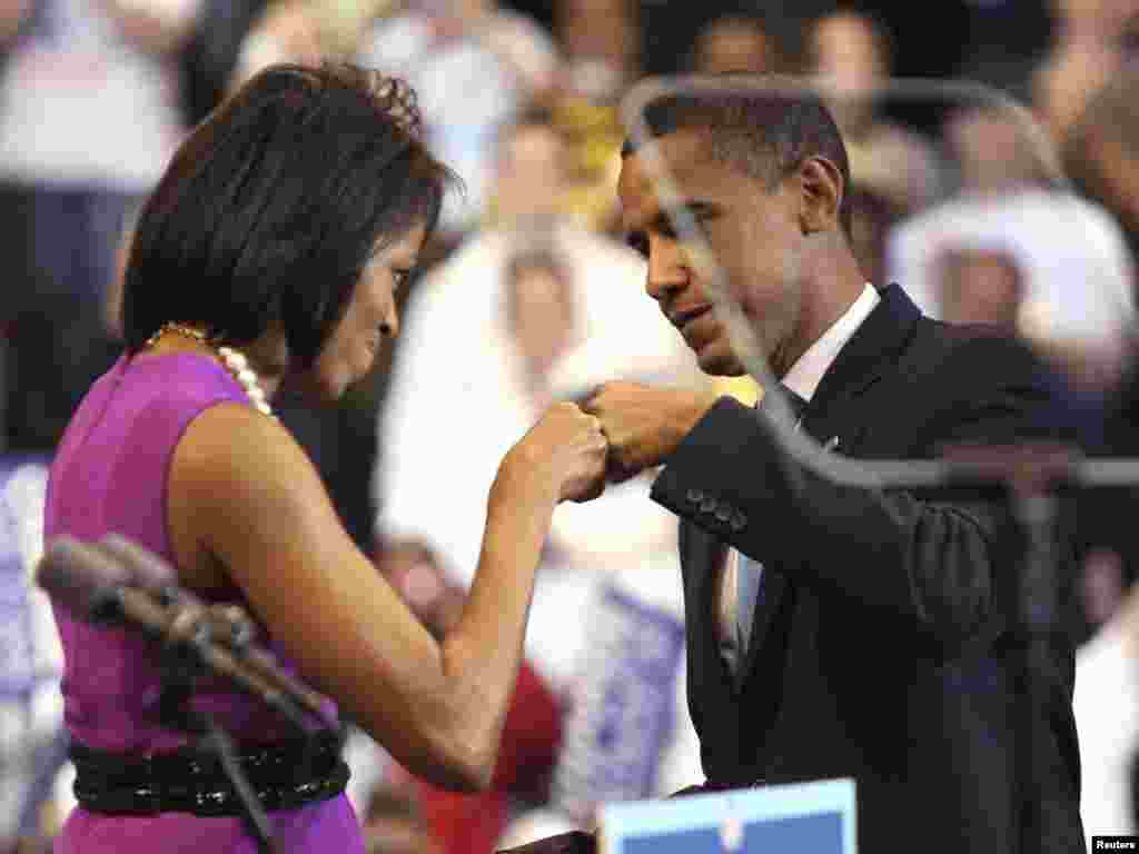 U.S. Democratic presidential candidate Senator Barack Obama (D-IL) bumps fists with his wife Michelle (L) before his speech at his South Dakota and Montana presidential primary election night rally in St. Paul, Minnesota, June 3, 2008. REUTERS/Eric Miller 
