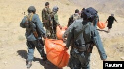 Afghan policemen carry the dead bodies of civilians who were killed by insurgents in Sar-e Pul Province in August of this year. (file photo)