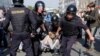 Russian policemen detain opposition supporters during a protest rally in Moscow on May 5. 