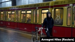 Nje grua me biçikletën e saj në Berlin, Gjermani.