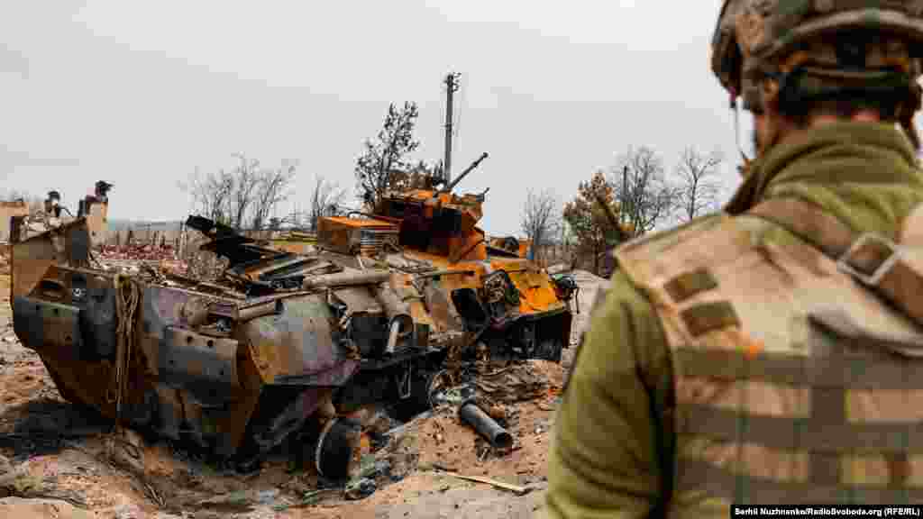 Український військовий&nbsp;оглядає знищений російський бронетранспортер БТР-82 у селі Тетерівське&nbsp;поблизу лінії фронту, 31 березня 2022 року 