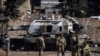 Ukrainian servicemen stand by a Russian army tank in the northeastern city of Trostianets, on March 29, 2022.