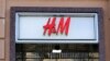 A woman stands next to a closed H&M store in Moscow, Russia March 3, 2022. REUTERS/Staff