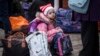 Një vajzë e vogël ukrainase duke pritur për t'u larguar nga Ukraina. 