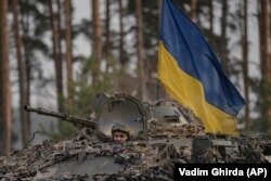 Ukrán katonák egy páncélozott járműben Kijevben 2022. március 31-én