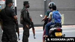 Илустративна фотографија/ Патниците се возат со скутер покрај војниците кои стојат на стража на улица во Коломбо, 2 април 2022