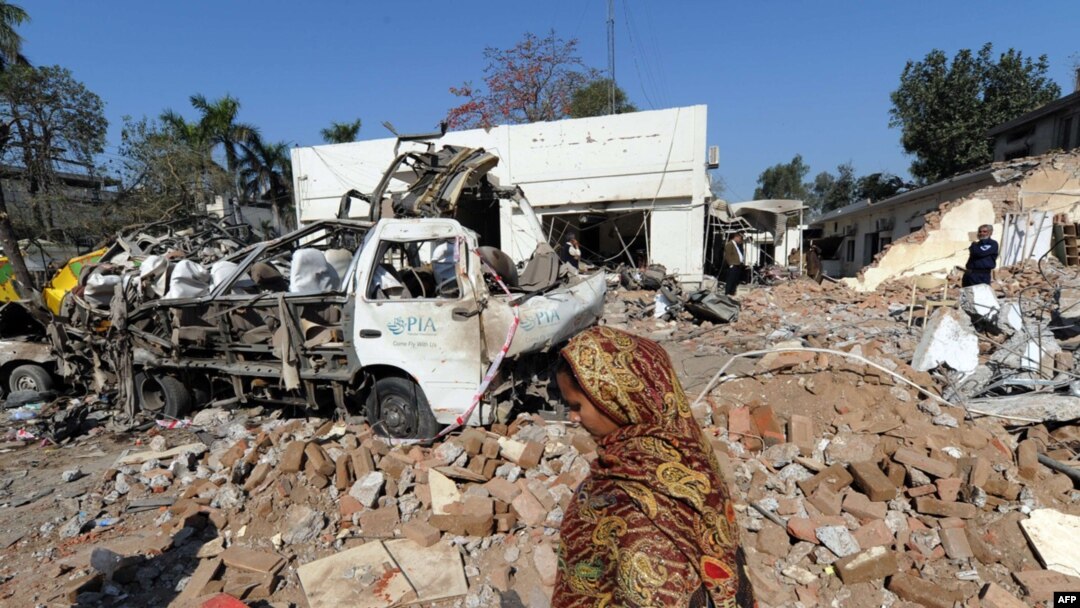  A resident walks past the wreckage from a deadly car bomb blast in Faisalabad on March 8.