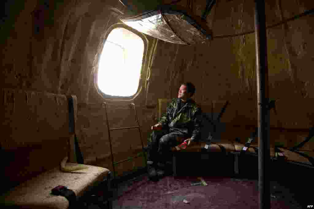 Farmer Liu Qiyuan sits inside one of seven survival pods at his home in the village of Qiantun in China&#39;s Hebei Province. Inspired by the apocalyptic Hollywood movie &quot;2012&quot; and the 2004 Asian tsunami, Liu hopes his creations, which consist of a fiberglass shell around a steel frame, will be adopted by governments and international organizations for use in the event of tsunamis and earthquakes. Liu has built seven pods, which are able to float on water, some of which have their own propulsion. The airtight spheres contain oxygen tanks and seatbelts with space for around 14 people and are designed to remain upright when in water. (AFP/Ed Jones)