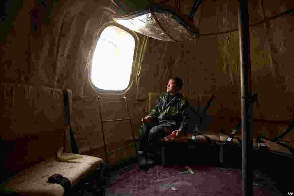 Farmer Liu Qiyuan sits inside one of seven survival pods at his home in the village of Qiantun in China's Hebei Province. Inspired by the apocalyptic Hollywood movie "2012" and the 2004 Asian tsunami, Liu hopes his creations, which consist of a fiberglass shell around a steel frame, will be adopted by governments and international organizations for use in the event of tsunamis and earthquakes. Liu has built seven pods, which are able to float on water, some of which have their own propulsion. The airtight spheres contain oxygen tanks and seatbelts with space for around 14 people and are designed to remain upright when in water. (AFP/Ed Jones)