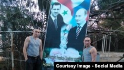 Росссийские солдаты в Сирии на фоне плаката с Башаром Асадом и Владимиром Путиным (архивное фото)