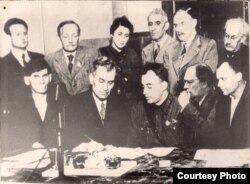 Першы Усеславянскі мітынг у Маскве. Янка Купала (стаіць 2-гі зьлева), Аляксей Талстой, Ванда Васілеўская, Аляксандар Карняйчук і інш. у час падпісаньня звароту да народаў сьвету. 11 жніўня 1941 г. З фондаў БДАМЛМ