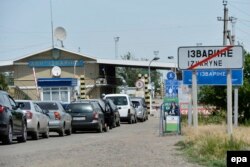 Mașini făcând coadă la un post de frontieră de lângă Luhansk.