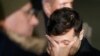 Ukrainian President Volodymyr Zelenskiy reacts as he waits to meet former Ukrainian prisoners.