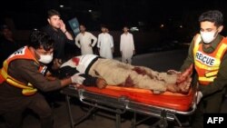 Volunteers move an injured policeman to a hospital following a bomb explosion in Peshawar on July 18.