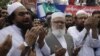 Hafiz Saeed, left, head of the banned Islamic charity Jamat-ud-Dawa, prays during a rally to mark Black Day, in Lahore, Pakistan, on July 19, 2016. 