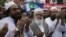 Hafiz Saeed, left, head of the banned Islamic charity Jamat-ud-Dawa, prays during a rally to mark Black Day, in Lahore, Pakistan, on July 19, 2016. 