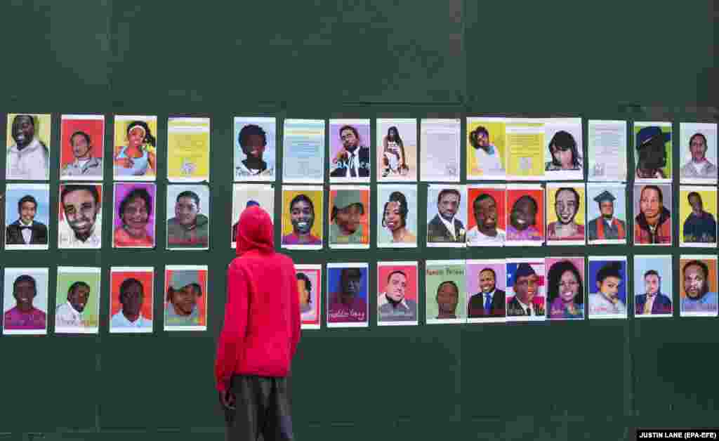 U.S. -- A man looks at photographs of people who have been killed by police pasted on a boarded up museum in New York, New York, USA, 18 June 2020.