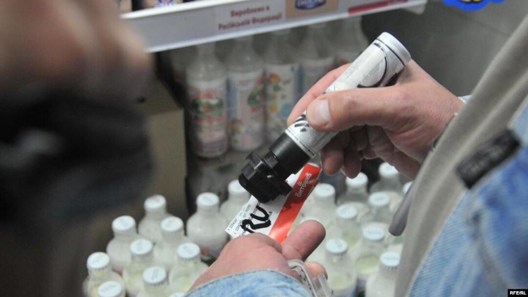 A store worker in Lviv marks products to indicate their Russian provenance. 