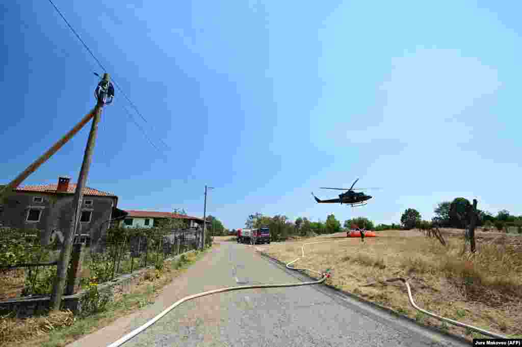 Helikopterët e ushtrisë së Sllovenisë duke u furnizuar me ujë për shuarjen e zjarreve në fshatin Lipe, më 22 korrik.