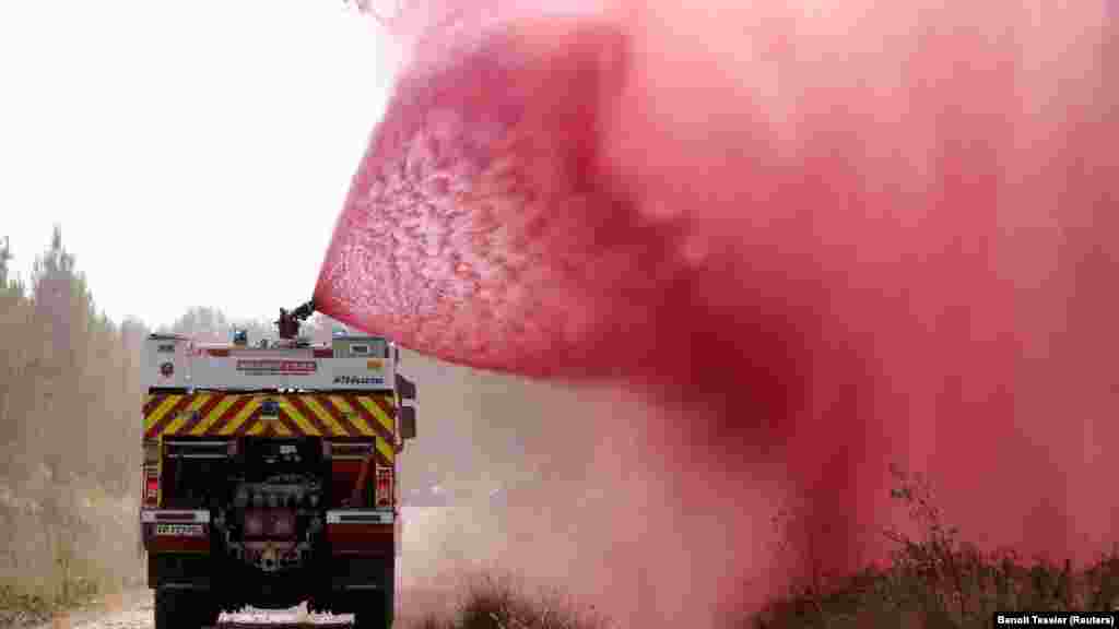 Vatrogasci prskaju sredstvo protiv požara u Hostensu u regiji Gironde na jugozapadu Francuske, 22. juli.