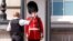 Un polițist dă apă unui soldat din Garda Regală la palatul Buckingam din Londra. 