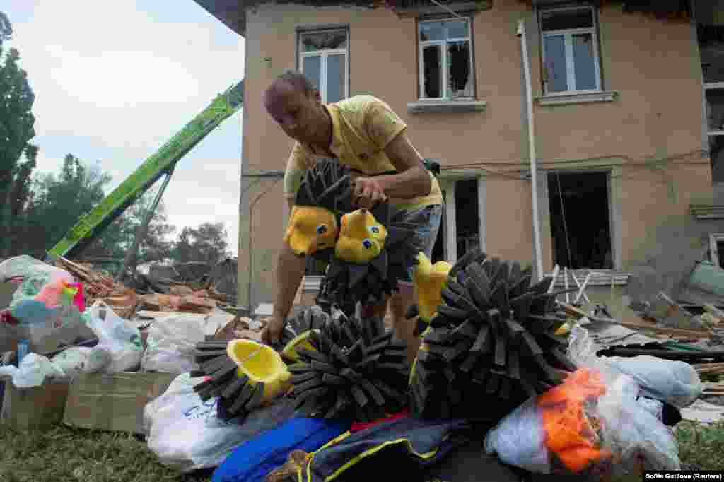 A man places children&#39;s costumes outside the House of Culture building that was destroyed by a Russian missile strike in the town of Chuhuiv in Ukraine&#39;s Kharkiv region.