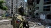 A Russian soldier patrols a destroyed residential area in the city of Syevyerodonetsk on July 12.