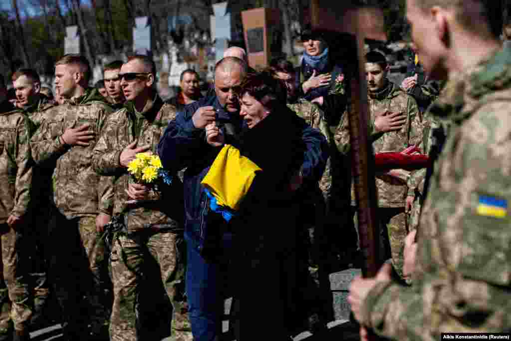 The mother of slain Ukrainian Senior Lieutenant Pavlo Chernikov is pictured as soldiers sing the Ukrainian national anthem at the Lychakiv cemetery in Lviv on March 28.&nbsp;