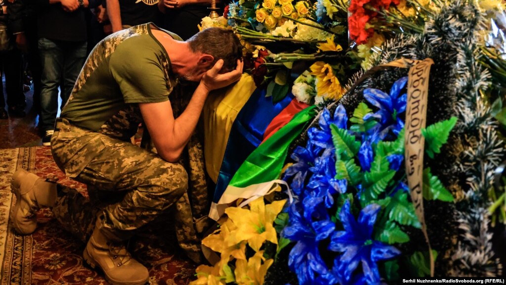 Një burrë duke qarë mbi funeralin e prezantuesit televiziv njëherësh ushtar ukrainas, Karim Gulamov, në Katedralen e Shën Michaelit në Kiev.