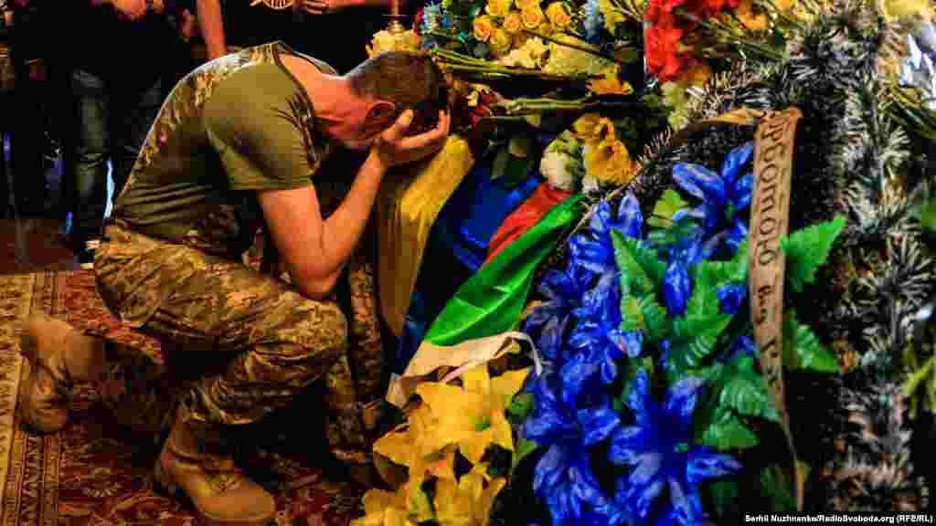 A man mourns at the funeral service for Ukrainian TV presenter and soldier Karim Gulamov, at St. Michael&#39;s Cathedral in Kyiv.