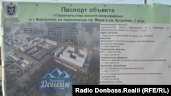 Стенд з планом будівництва, виставлений біля будівельного майданчик