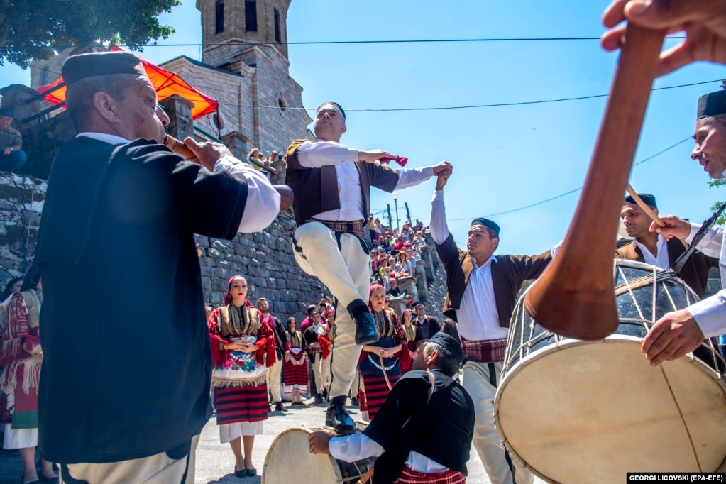 Burrat e veshur me kostume tradicionale duke vallëzuar.