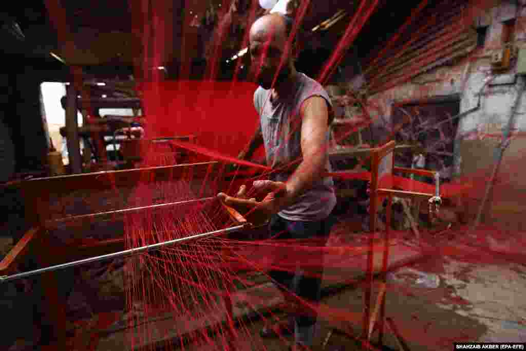 A laborer works at a power loom in Karachi, Pakistan.