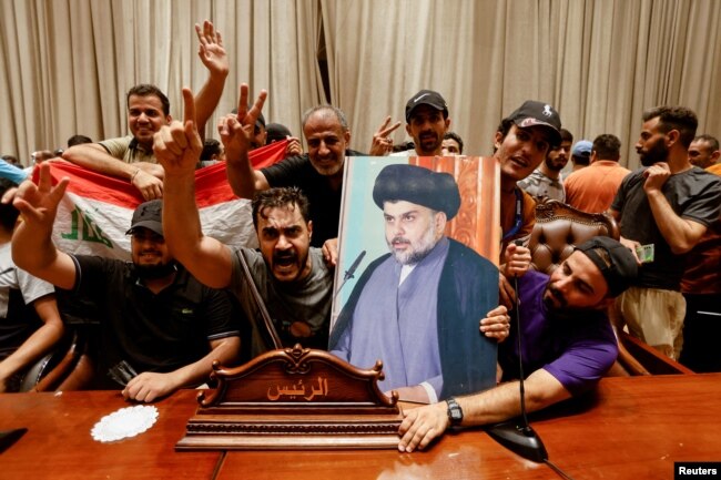 Mbështetësit e klerikut Moqtada al-Sadr, duke mbajtur fotografinë e tij gjatë protestave në Parlament.