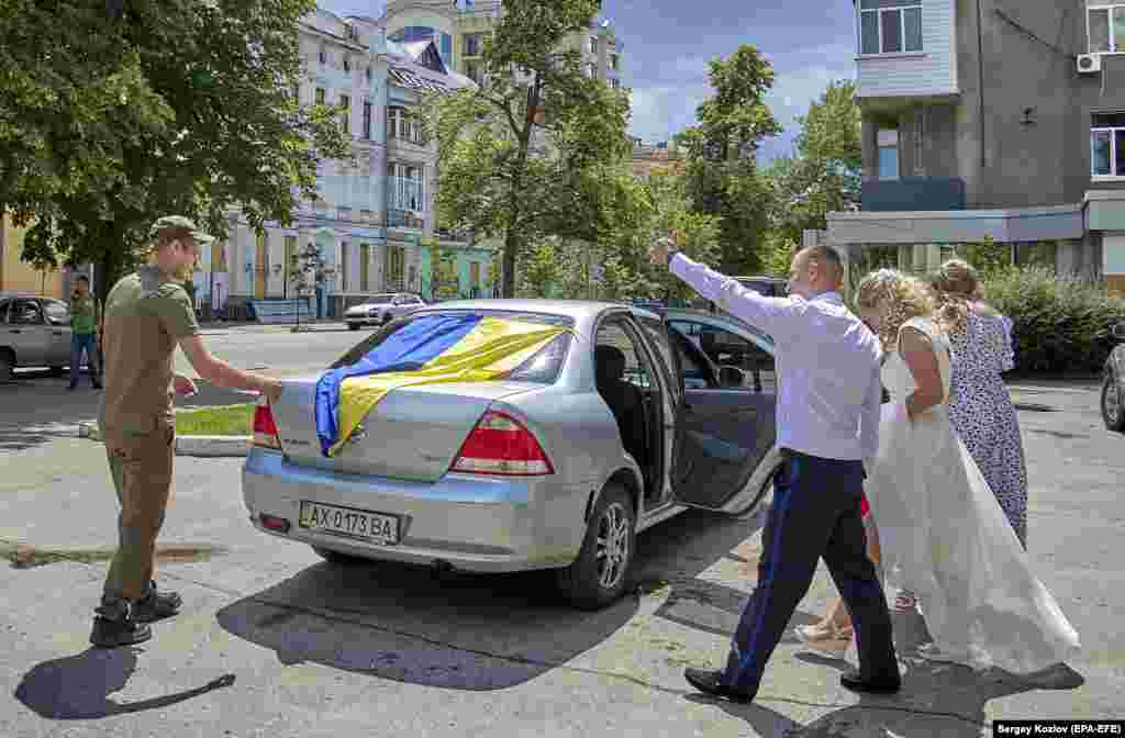 Военнослужащий Нацгвардии Игорь и его невеста Кира выходят из подвала ЗАГСа в Харькове 23 июня. Из-за угрозы обстрелов свадьбы в Харькове сейчас часто проводятся в подземных помещениях.
