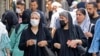 Women wearing head scarves walk in the streets of Tehran on July 12. Since the country's 1979 Islamic revolution, Iranian law requires all women to wear a hijab that covers the head and neck while concealing the hair. But many have pushed the boundaries over the past two decades.