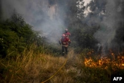 A Portugália északi részén lévő Eiriz mellett küzdenek a tűzoltók az erdőtűzzel, 2022. július 15-én.