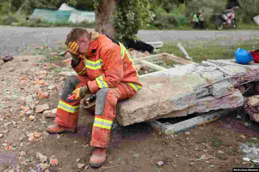 A firefighter pauses in the search for bodies in the rubble of the Central House of Culture after a Russian military strike hit the building in&nbsp;Chuhuiv in Ukraine&#39;s Kharkiv region.
