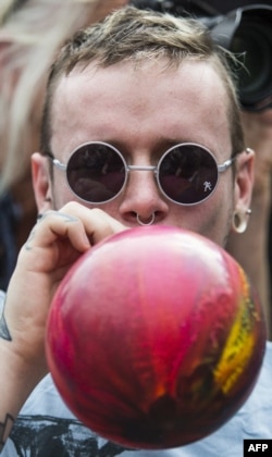  Мъж вдишва божествен газ. Снимката е правена в Лондон през 2015 година 