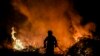 Vatrogasac gasi šumski požar oko sela Eiriz u Baiaou, sjeverno od Portugala, 15. jula 2022.