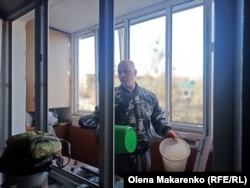 Serhiy Khomenko cleans his apartment, which was damaged by a shock wave.