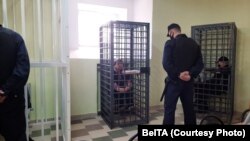 The defendants, kept in separate cages, attend their trial at a Hrodna court in July.