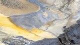 Two miners walk through an open copper pit in the Serbian town of Bor.