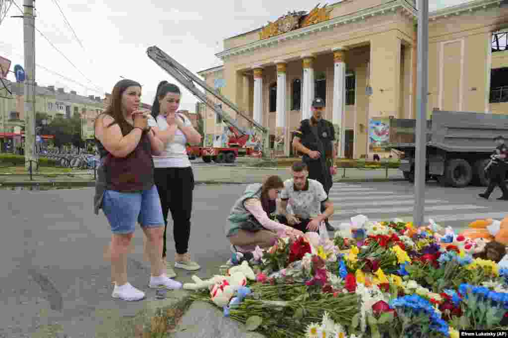 People pray and lay flowers at the site of a Russian shelling attack on Vinnytsya, Ukraine. At least 23 people were killed including three children.