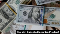 Kartmonedha në dollarë dhe në monedhën kombëtare ukrainse, hrivnia. Fotografi ilustruese. 