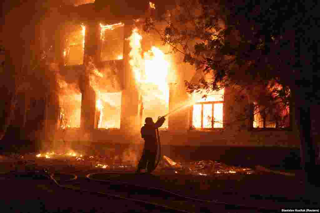 A firefighter extinguishes a burning hospital building hit by a Russian missile strike in Mykolayiv, Ukraine.&nbsp;