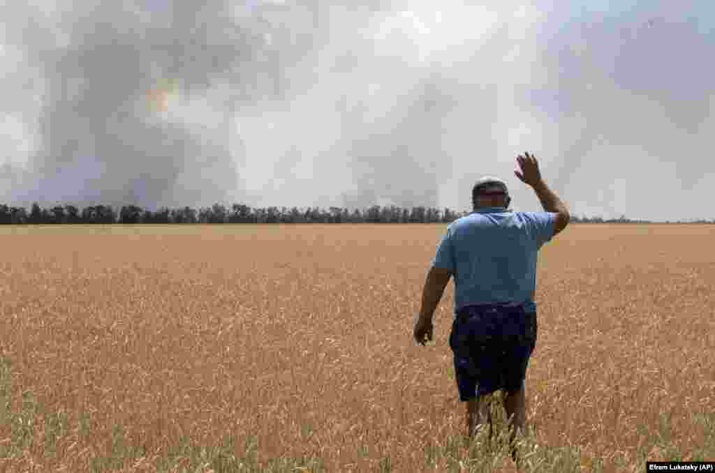Украински земјоделец во регионот Дњепропетровск гледа како неговите полиња со жито горат поради борбите.