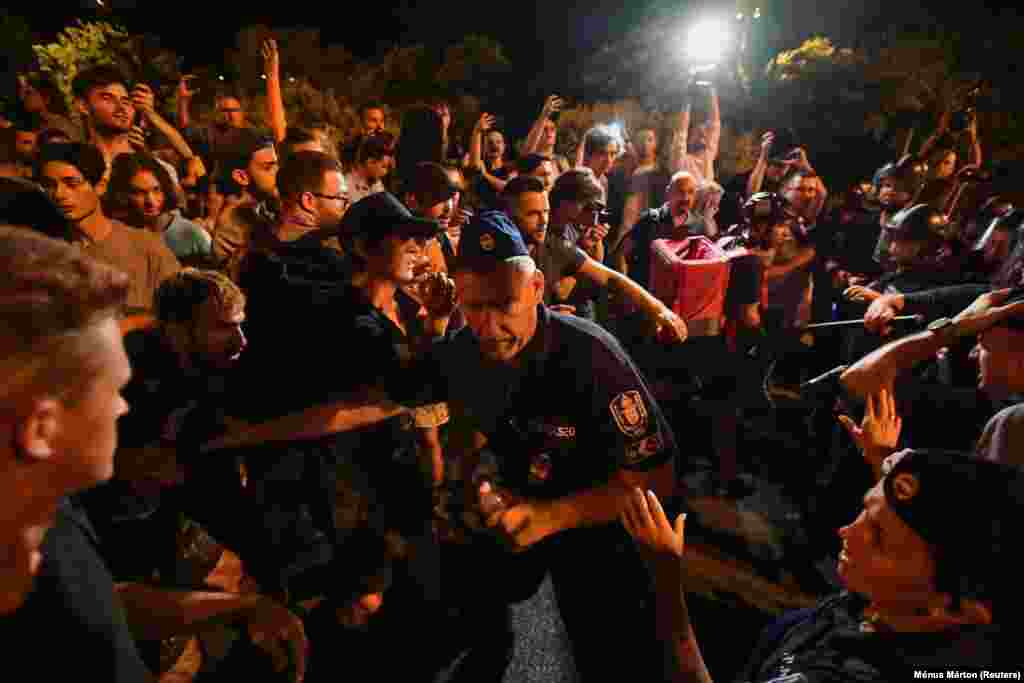 A Karmelita kolostor volt a végcél, a Dísz téren a rendőrök sorfalat álltak a demonstrálókkal szemben, akik nemcsak azt kiabálták, hogy &quot;Konzultálni jöttünk!&quot;, &quot;Mocskos Fidesz!&quot;, vagy &quot;Orbán, takarodj!&quot;, de a rendőröknek is magasabb béreket követeltek&nbsp;