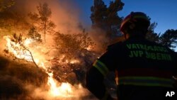 Vatrogasac pored šumskog požara u Zatonu u Hrvatskoj 13. juli 2022. 